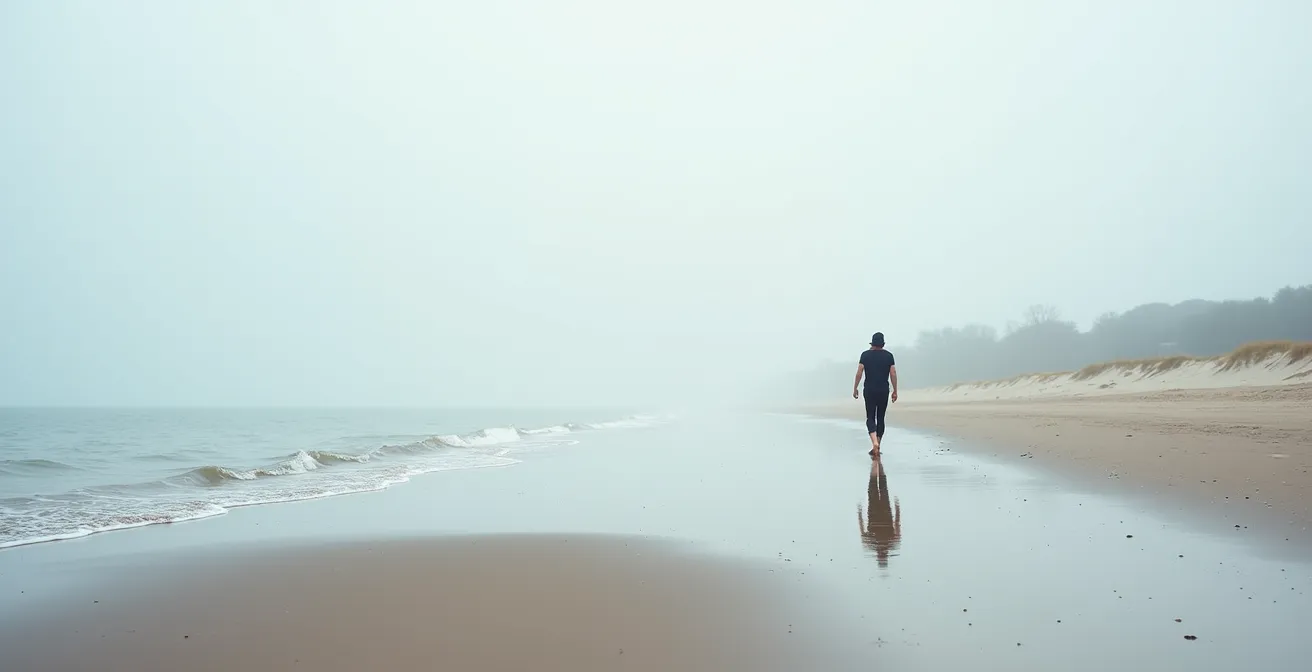 Weitläufiger Nordseestrand mit Person beim therapeutischen Strandspaziergang